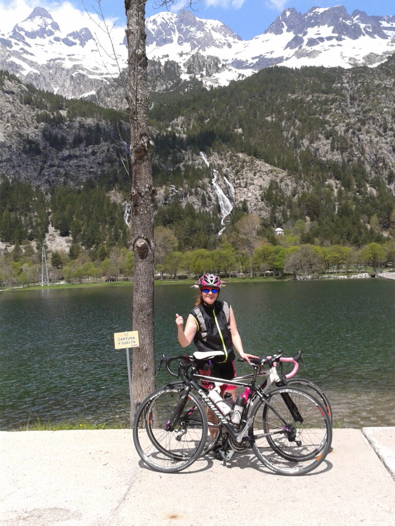 Chica ciclista con lago y montañas en Biescas