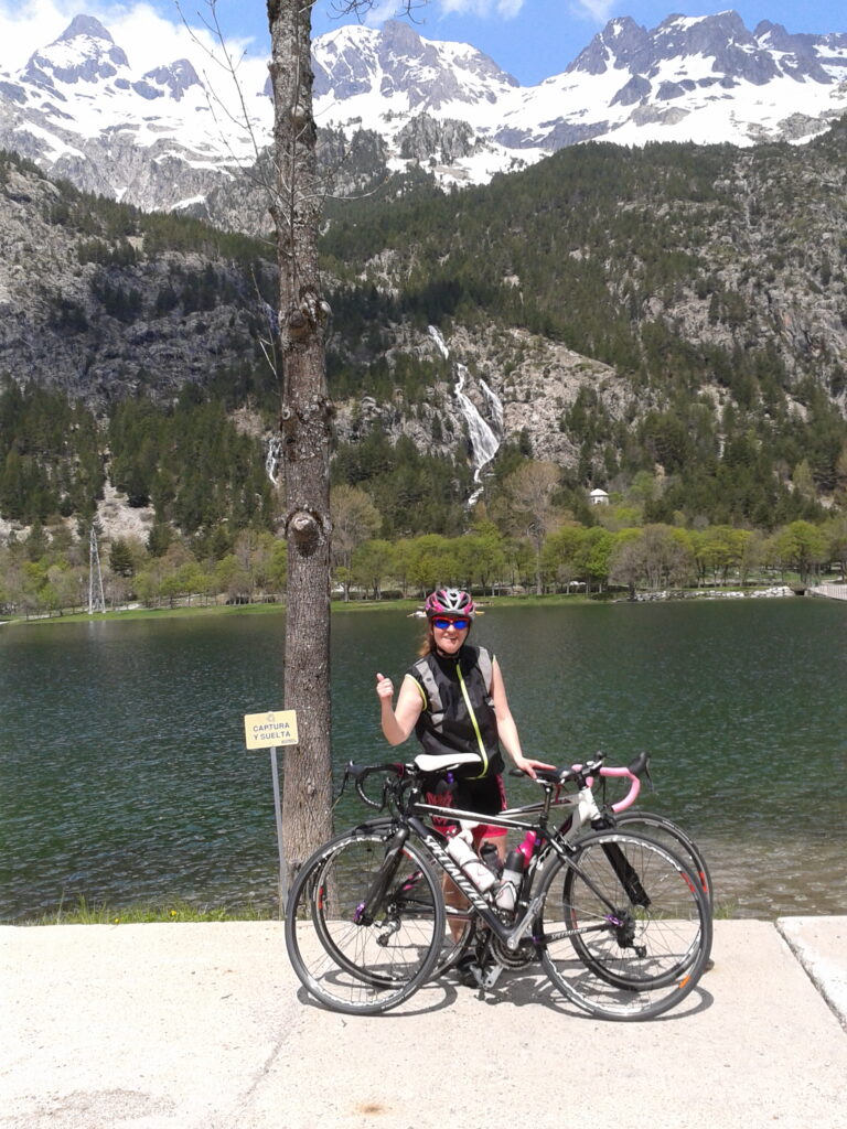 Cycling girl with lake and mountains in Biescas